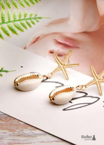 Pendientes bohemios colgantes de concha de estrella de mar y cauri en oro blanco.